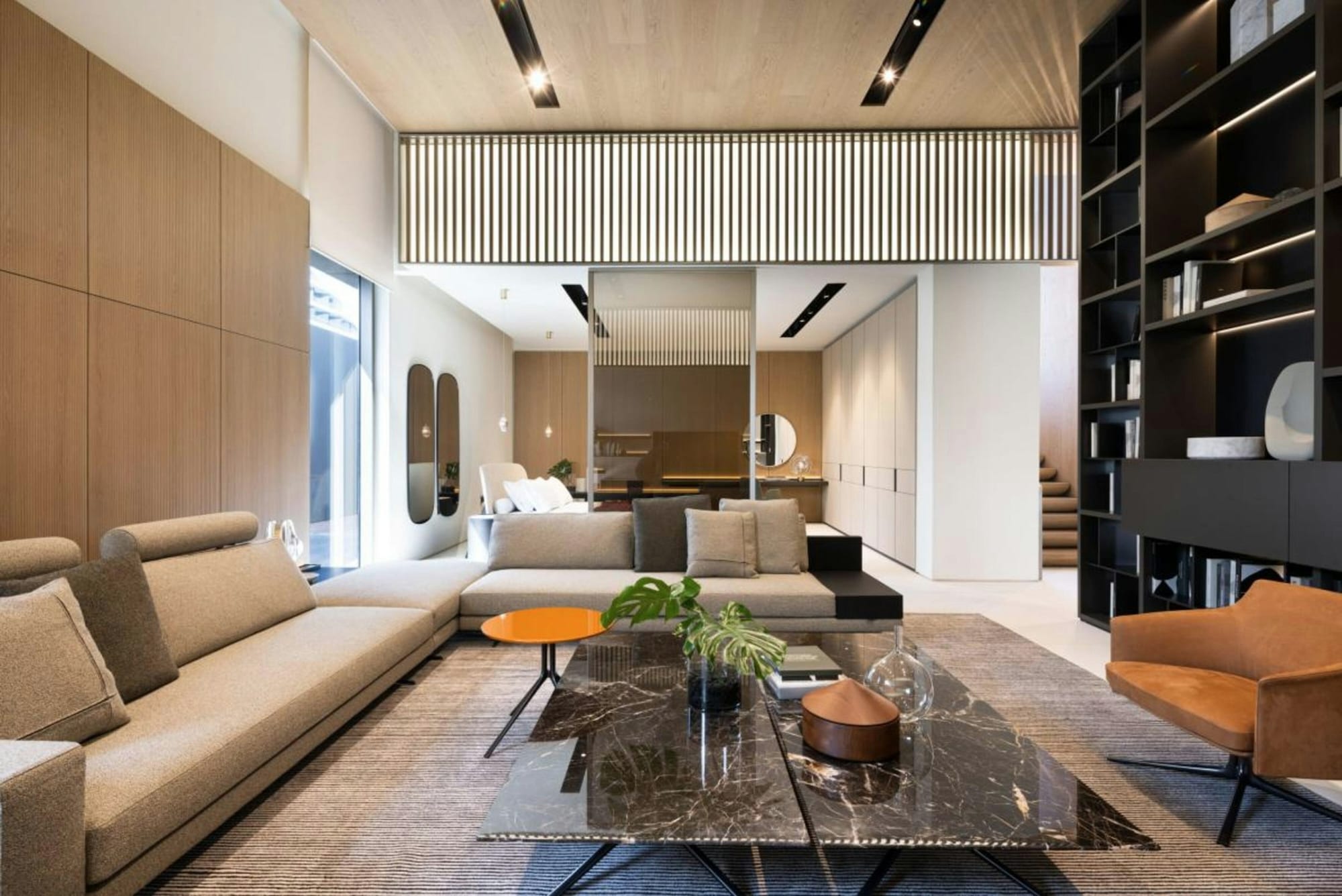 A finished great room: low sofas, a stone coffee table and built-in shelving.